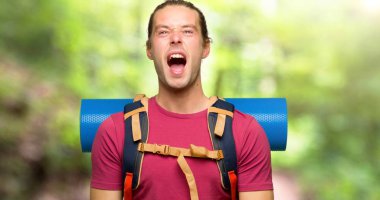 Dağ backpacker dağ geniş açık ağız ile ön bağıran adamla uzun yürüyüşe çıkan kimse