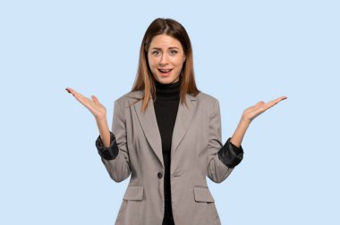 İş kadını izole mavi arka plan üzerinde şok yüz ifadesi ile