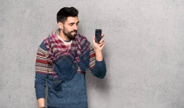 Kırık smartphone dokulu duvar'ın üstüne tutan hippi adamla sorunlu