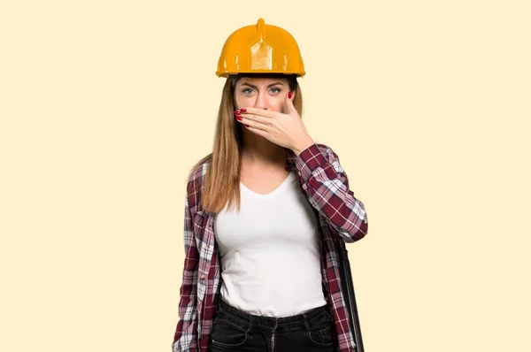 分離された黄色の背景に不適切な何かを言うための手で口を覆っている女性の建築家します — ストック写真