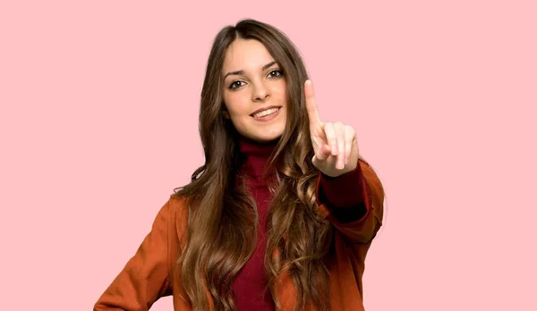 Молодая Женщина Пальто Показывает Поднимает Палец Изолированном Розовом Фоне — стоковое фото