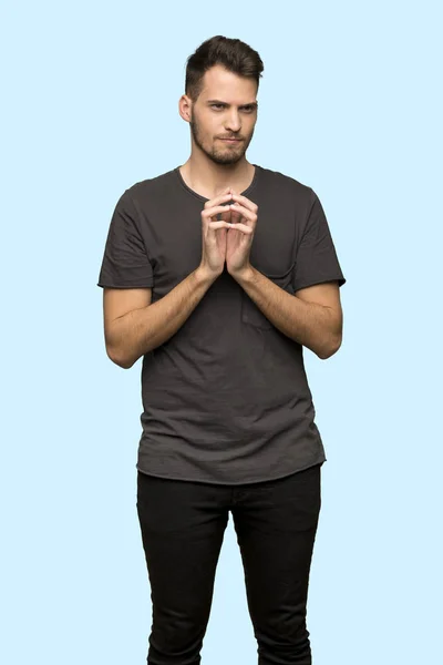 Man Met Zwarte Shirt Gekonkel Iets Blauwe Achtergrond — Stockfoto