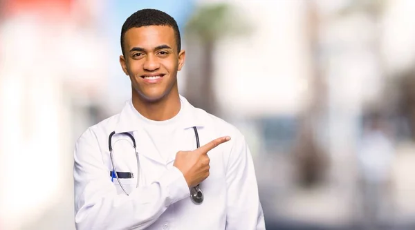 Young Afro American Man Doctor Pointing Side Present Product Outdoors — Stockfoto