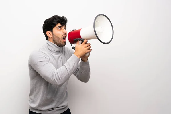 Joven Sobre Una Pared Blanca Aislada Gritando Través Megáfono —  Fotos de Stock