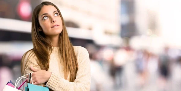 Chica Joven Con Bolsas Compras Con Expresión Cara Confusa Mientras — Foto de Stock