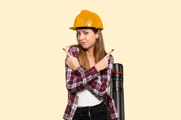 Architect Woman Wijzend Naar Laterals Twijfels Geïsoleerde Gele Achtergrond — Stockfoto