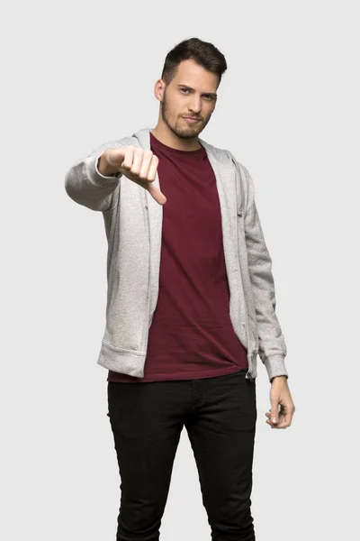 Mann Mit Sweatshirt Zeigt Daumendrücker Mit Negativem Gesichtsausdruck Über Grauem — Stockfoto