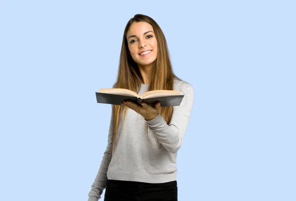 Jovem Segurando Livro Dando Alguém Fundo Azul — Fotografia de Stock