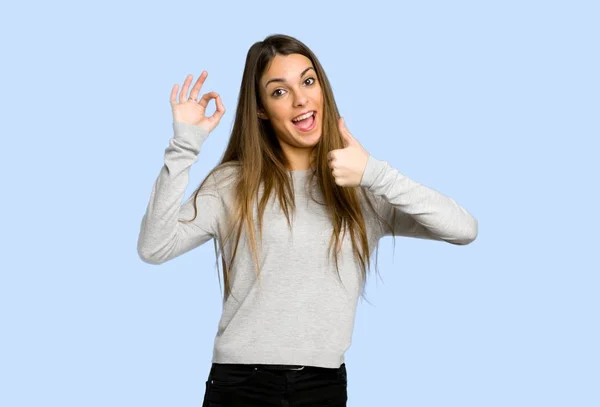 Genç Kız Gösteren Işareti Ile Mavi Arka Plan Üzerinde Bir — Stok fotoğraf