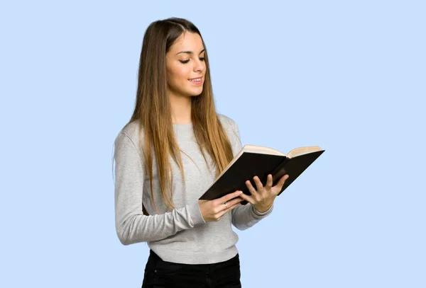 Young Girl Holding Book Enjoying Reading Blue Background — Stock Photo, Image