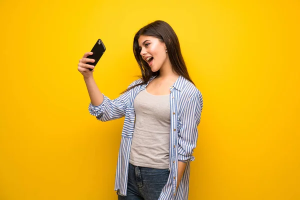 Adolescente Chica Sobre Amarillo Pared Haciendo Selfie —  Fotos de Stock