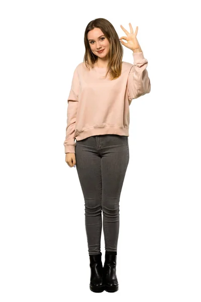 一个少年女孩与粉红色毛衣的全长拍摄显示确定的标志与手指在孤立的白色背景 — 图库照片