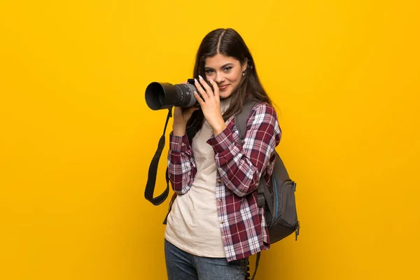 黄色の壁の上のカメラマンのティーンエイ ジャーの女の子 — ストック写真