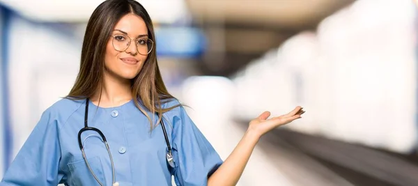 Jovem Enfermeira Segurando Copyspace Imaginário Palma Mão Para Inserir Anúncio — Fotografia de Stock