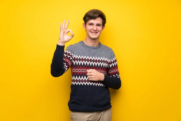 Nastolatek Mężczyzna Nad Żółte Ściany Wyświetlono Znak Palcami — Zdjęcie stockowe