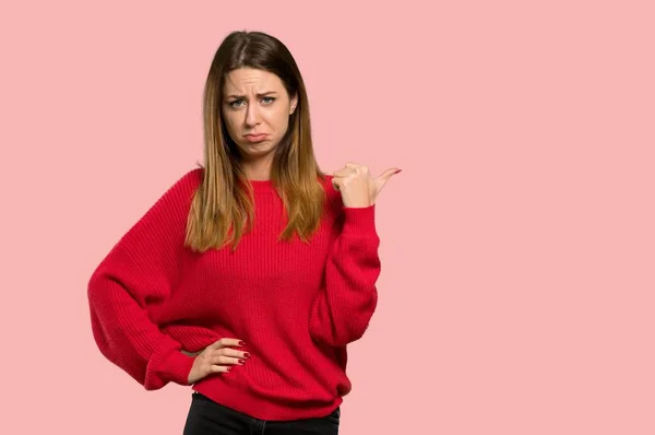 Young Woman Red Sweater Unhappy Pointing Side Isolated Pink Background — Stock Photo, Image