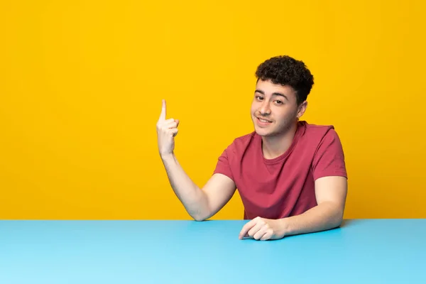 Jovem Com Parede Colorida Mesa Mostrando Levantando Dedo Sinal Melhor — Fotografia de Stock