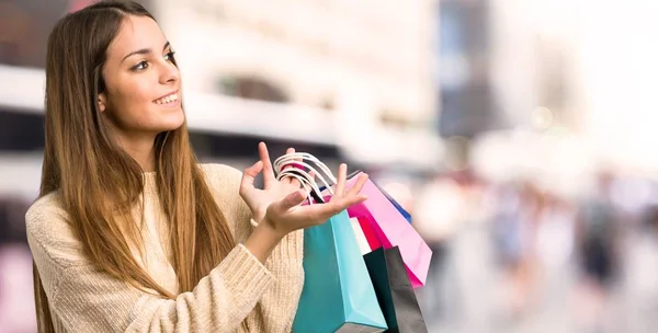 Junges Mädchen Mit Einkaufstüten Die Die Hände Zur Seite Reichen — Stockfoto