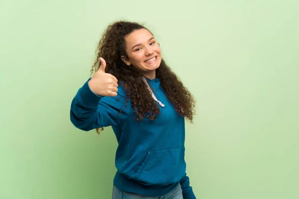 Adolescente Menina Sobre Parede Verde Dando Gesto Polegares Para Cima — Fotografia de Stock