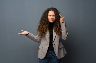 Genç kız mavi duvar parmak kafasına koyarak delilik jest yapma