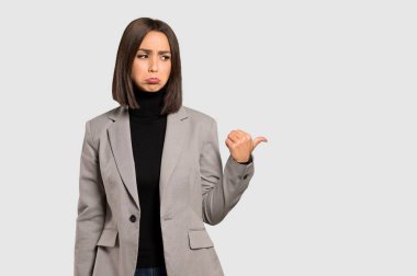 Genç iş kadını mutsuz ve izole gri arka tarafa işaretleme