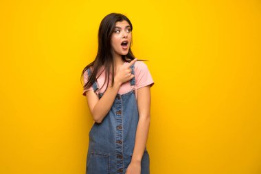 Genç kız şaşırttı ve yan işaret sarı duvarın üzerinden