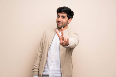 Gülümseyen ve zafer işaret gösteren izole duvarın üzerinden genç adam