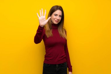 Beş parmak ile sayma sarı duvarın üzerinden balıkçı yaka kadınla