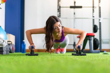 Genç kadın şınav bir spor salonunda spor