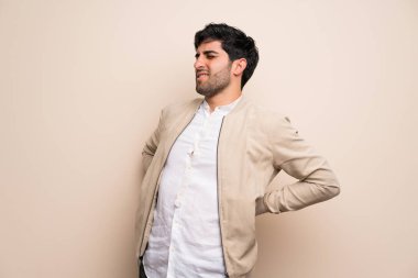 Genç adam için bir çaba yapılmış olan sırt ağrısı muzdarip izole duvarın üzerinden