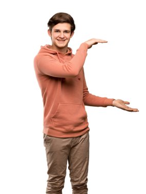 Genç adam kazak boşaltmak holding ile izole beyaz arka plan üzerinde bir reklam eklemek için