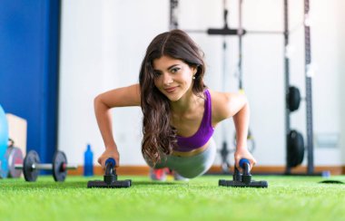 Genç kadın şınav bir spor salonunda spor