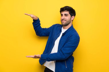 Mavi ceket ve sarı duvarın boşaltmak holding üzerinden adamla bir reklam eklemek için