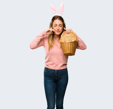 Tavşan kulaklar kulaklar elleriyle kapsayan Paskalya tatili için giyen genç kadın. Hayal kırıklığı ifade izole gri arka plan üzerinde
