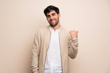 Ürün sunmak için yalıtılmış duvar tarafına işaret eden genç adam