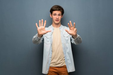 Jean ceket gri duvar dokuz parmaklı sayma üzerinde olan genç adam