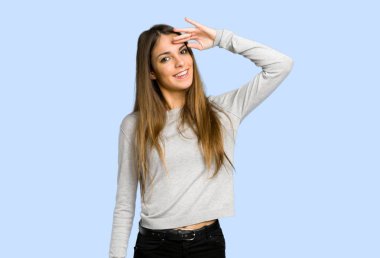 genç kız mavi arka plan üzerinde el ile selamlayan