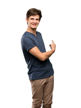 Genç adam geri izole beyaz arka plan üzerinde işaret