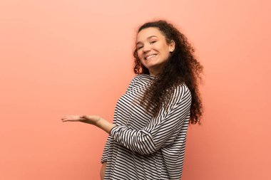 Genç kız pembe duvar görünümlü doğru gülümseyen iken bir fikir sunmak