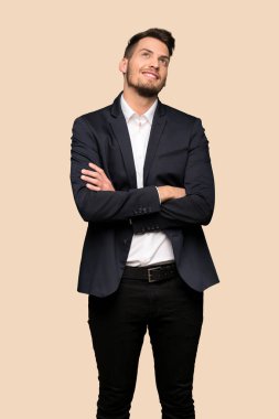 Koyu sarı arka plan üzerinde gülümseyen ararken yakışıklı iş adamı