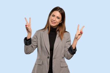 Gülümseyen ve her ikisi de zafer işaretiyle gösterilen iş kadını izole mavi arka plan üzerinde eller