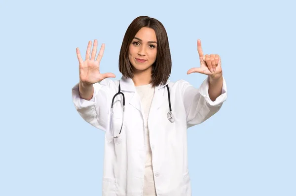 Jovem Médica Mulher Contando Sete Com Dedos Fundo Azul Isolado — Fotografia de Stock