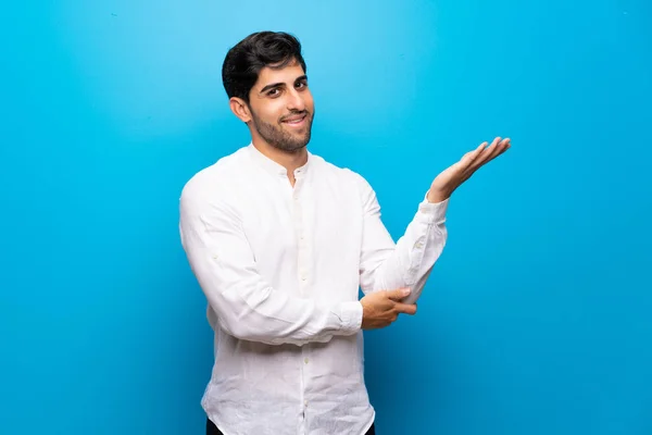 Jeune Homme Sur Mur Bleu Isolé Étendant Les Mains Sur — Photo