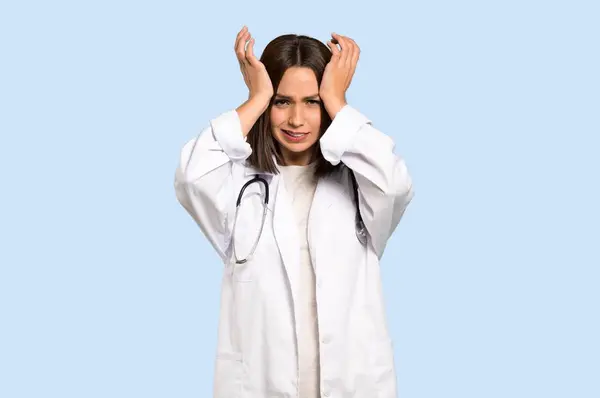 Jovem Médico Mulher Frustrada Toma Mãos Cabeça Fundo Azul Isolado — Fotografia de Stock
