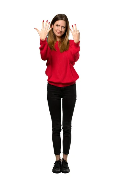 分離の白い背景の上の指で を数える赤いセーターを持つ若い女性のフルレングス ショット — ストック写真