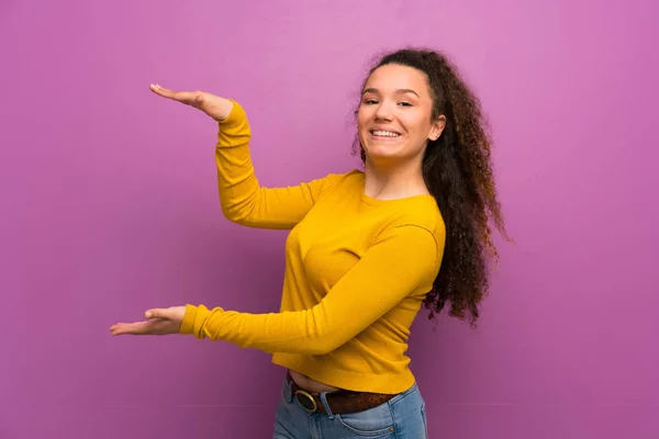 広告を挿入する Copyspace を保持している紫の壁を越えてティーンエイ ジャーの女の子 — ストック写真