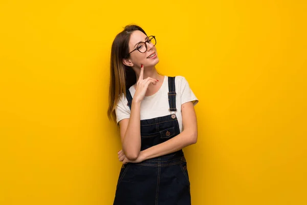 Wanita Atas Dinding Kuning Memikirkan Ide Saat Melihat Atas — Stok Foto