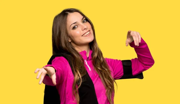 ヤング スポーツながら微笑む分離された黄色の背景で女性ポイントの指 — ストック写真