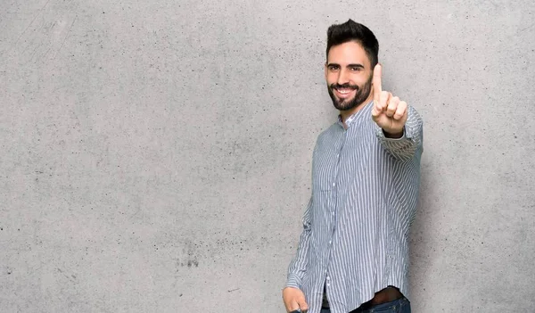 Elegante Hombre Con Camisa Mostrando Levantando Dedo Sobre Pared Texturizada —  Fotos de Stock