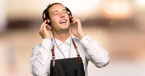 Kapper Man Een Schort Luisteren Naar Muziek Met Koptelefoon Een — Stockfoto